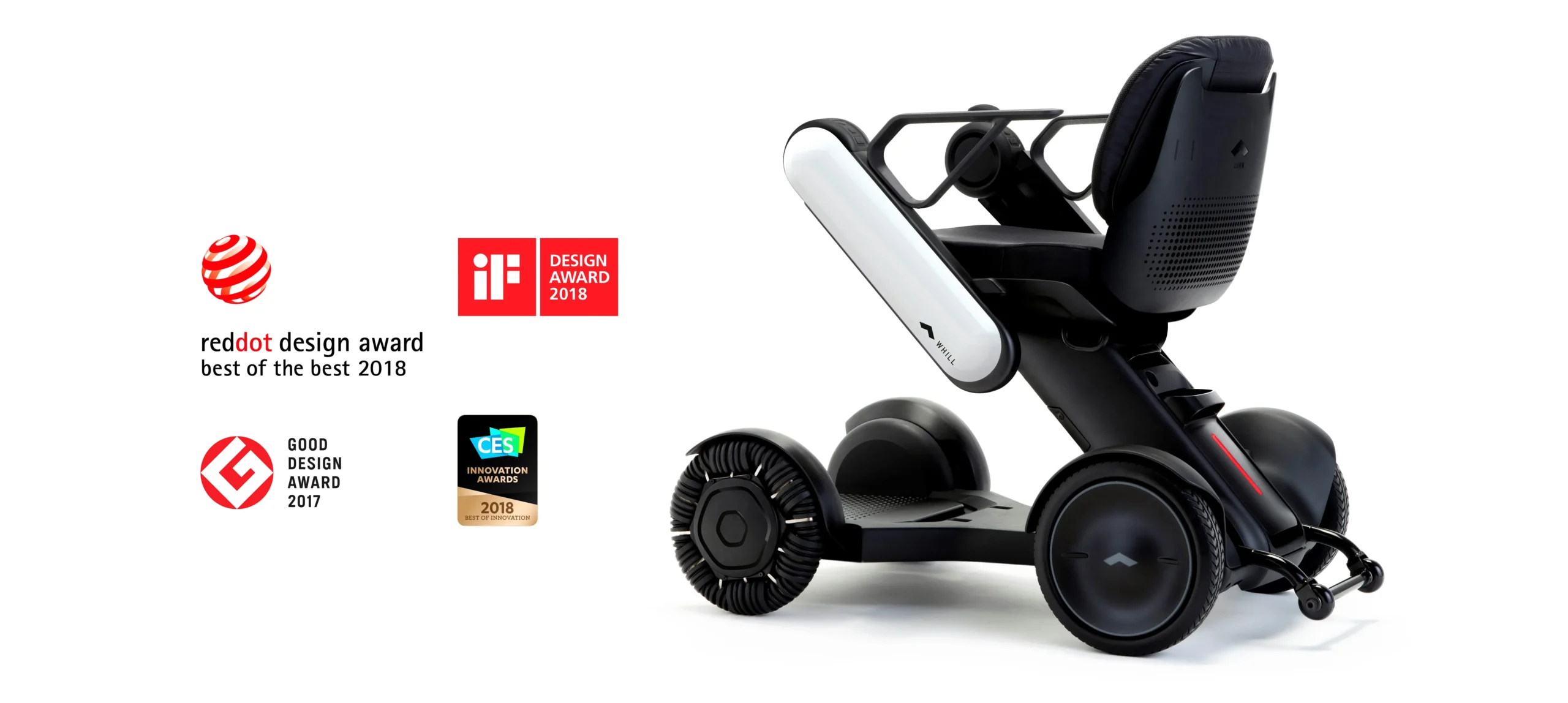 A WHILL Model C2 power chair with omni wheels and a modern design. It’s displayed beside award logos from 2017 and 2018, suggesting innovation.