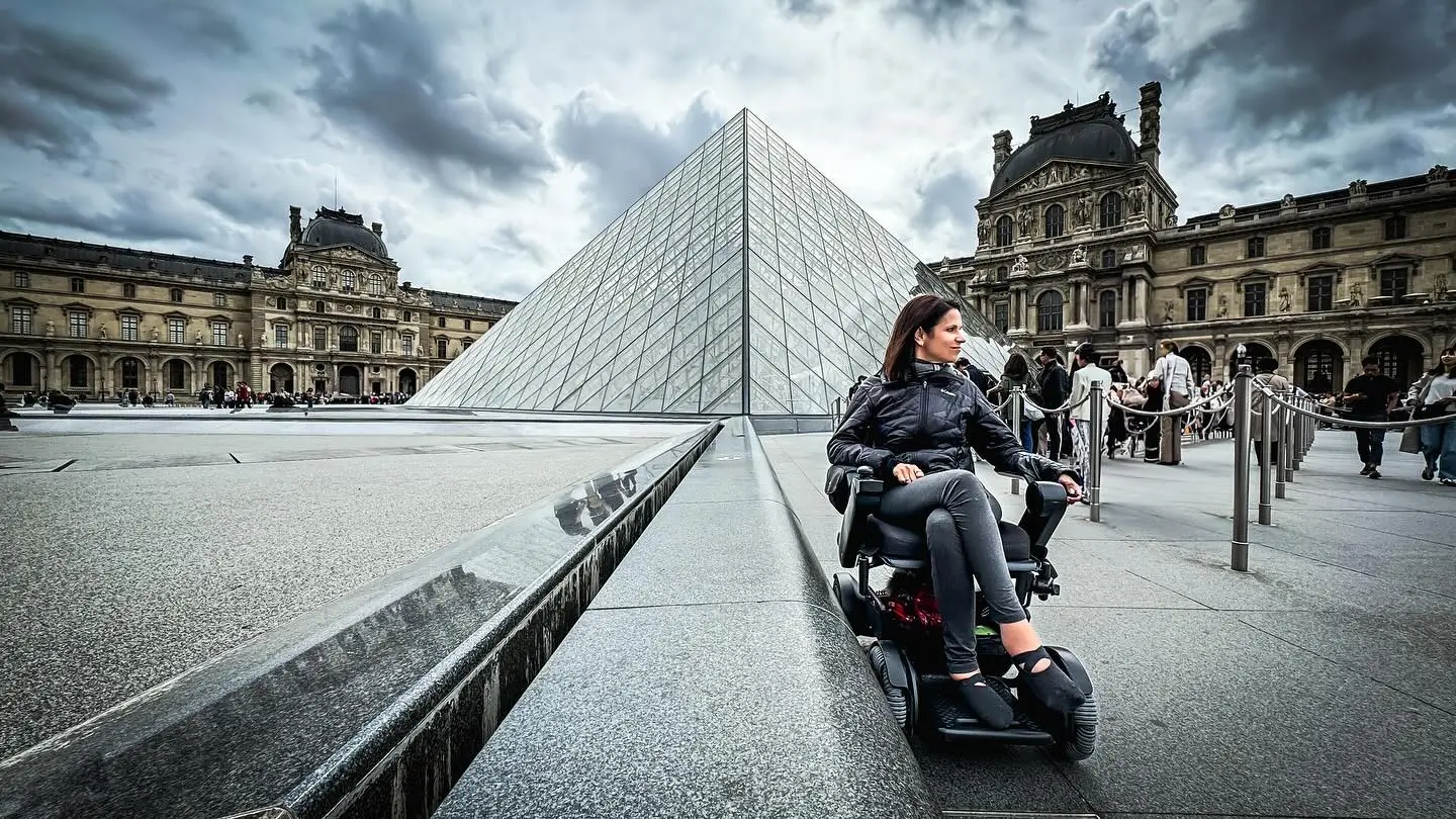 Women outside on a WHILL Model C2 portable powerchair.